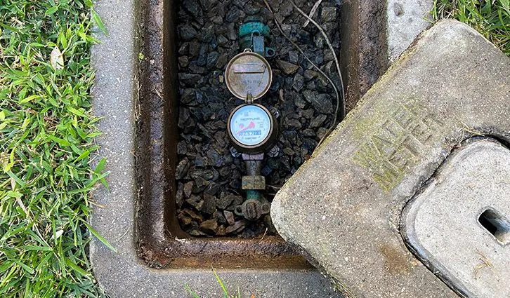 Residential water meter inside an open in-ground meter box